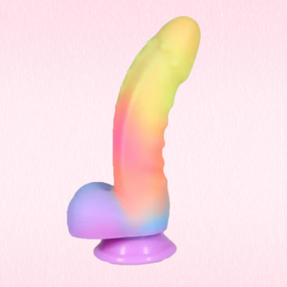 A curved dildo with a suction cup base, featuring a smooth pastel rainbow gradient  set against a light pink textured background.