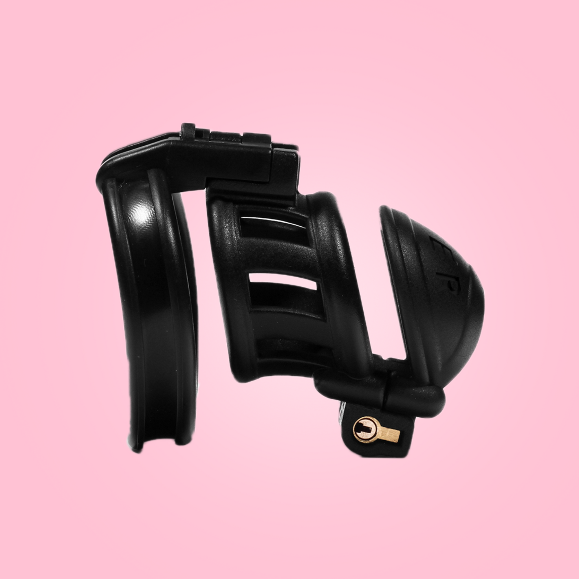 Showing the small design of the slaver, that comes in 3 different sizes: micro, small and standard double lock cock cages. Made from black resin, with Slaver imprinted on the head.