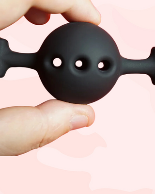A close up of the silicone ball gag air holes, it is being held 