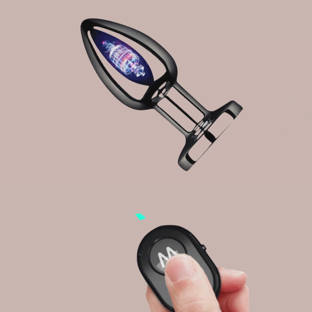 A side profile of the wireless vibrating stainless steel anal plug, it shows the battery inside to suggest how the wireless control is used. Also shown is the small hand control for the device.