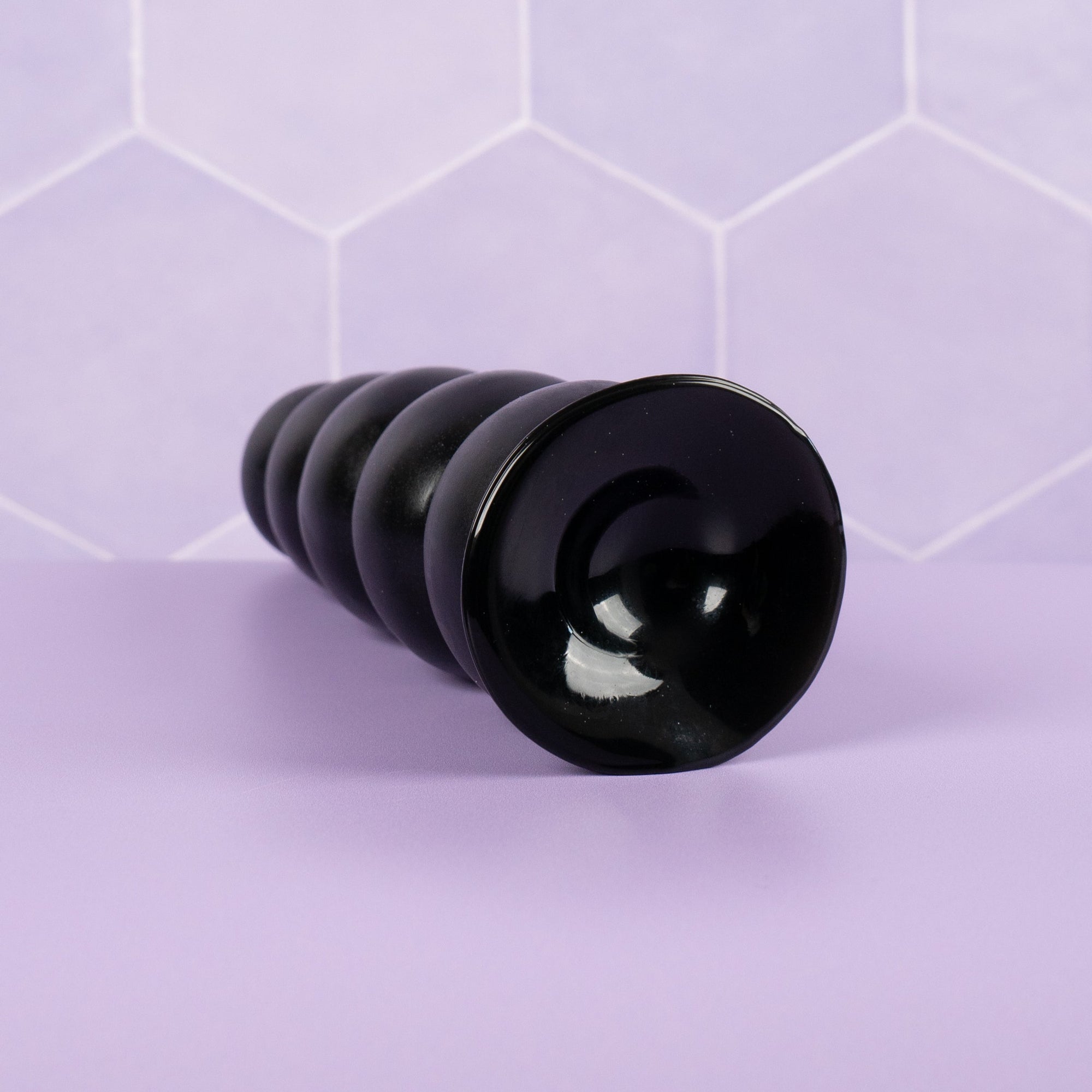 Showing the suckered base of The Amative anal dildo, this dildo can be affixed to a flat surface for personal play time.