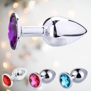 Showing four different coloured large stainless steel butt plugs. There is a side view of the purple plug, then side by side at the bottom of the picture are red, pink and blue butt plugs.