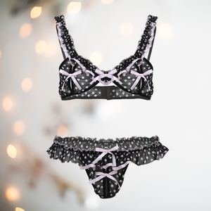A very pretty bra and knicker set in black see through chiffon with pink spot pattern, ruched fabric and pink ribbon detailing.The bra is a peep hole style with pink bows placed in the centre of the cup to stop the fabric opening fully. The matching knickers are bikini style with a thong back.  