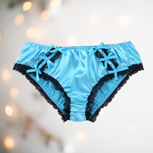 Shown unworn, Adult knickers for men, sissy, lgbt, unisex. Made in blue satin with black lace detailing to the legs and panels on each side. There are also matching blue satin bows prettily applied.