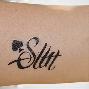 An image of the Slut temporary tattoo from House Of Chastity shown when applied to the skin.