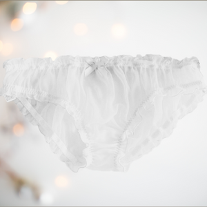 A close up of the white see through panties, you can see the elasticated waist and legs, and the decorative matching bow.